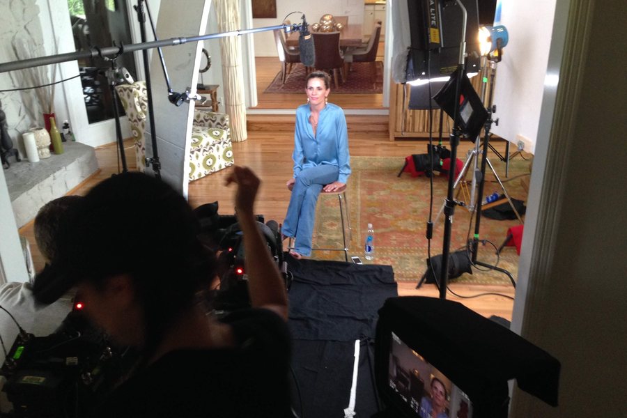 A lit interview set with camera operator and subject